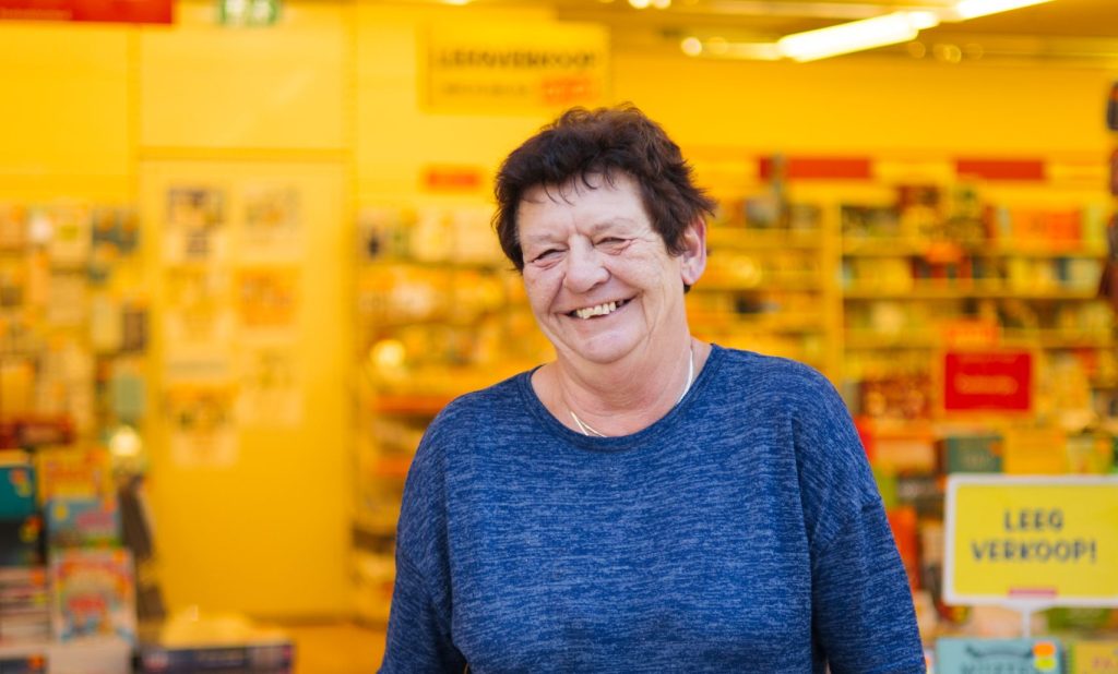 Onderneemster BoekenVoordeel poseert in haar winkel