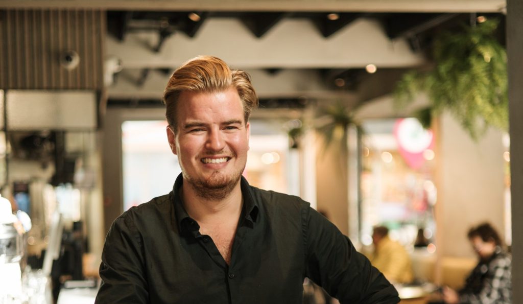 Ondernemer Martinus Eten en Drinken poseert in zijn restaurant