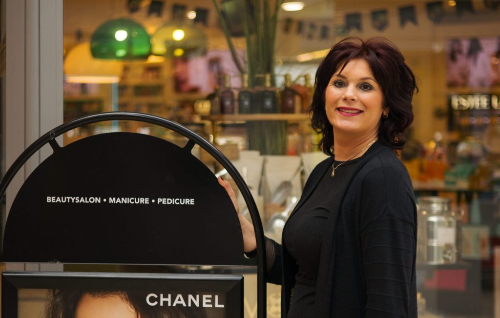 Onderneemster Parfumerie MOOI poseert voor haar winkel